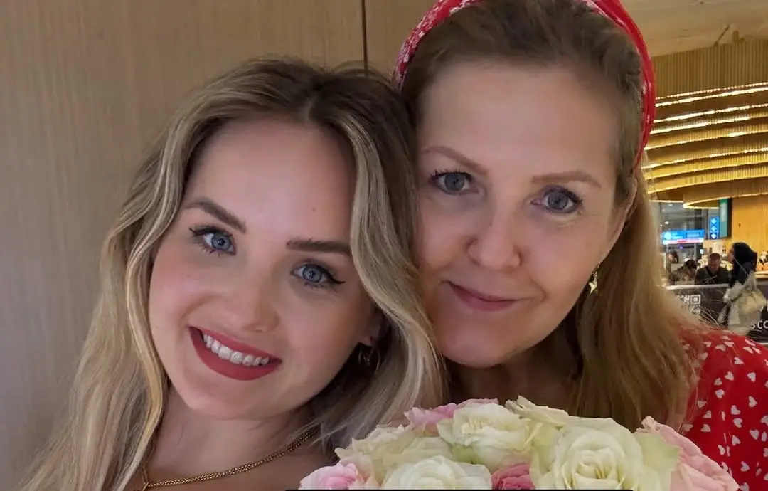 Natalie Kusnik abrazada a su madre, con un ramo de rosas